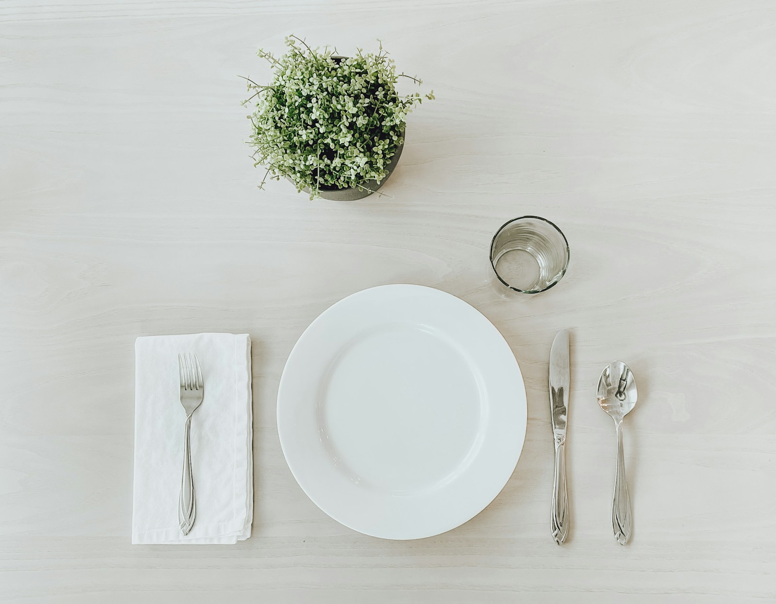 Assiette en céramique blanche avec couverts et pain