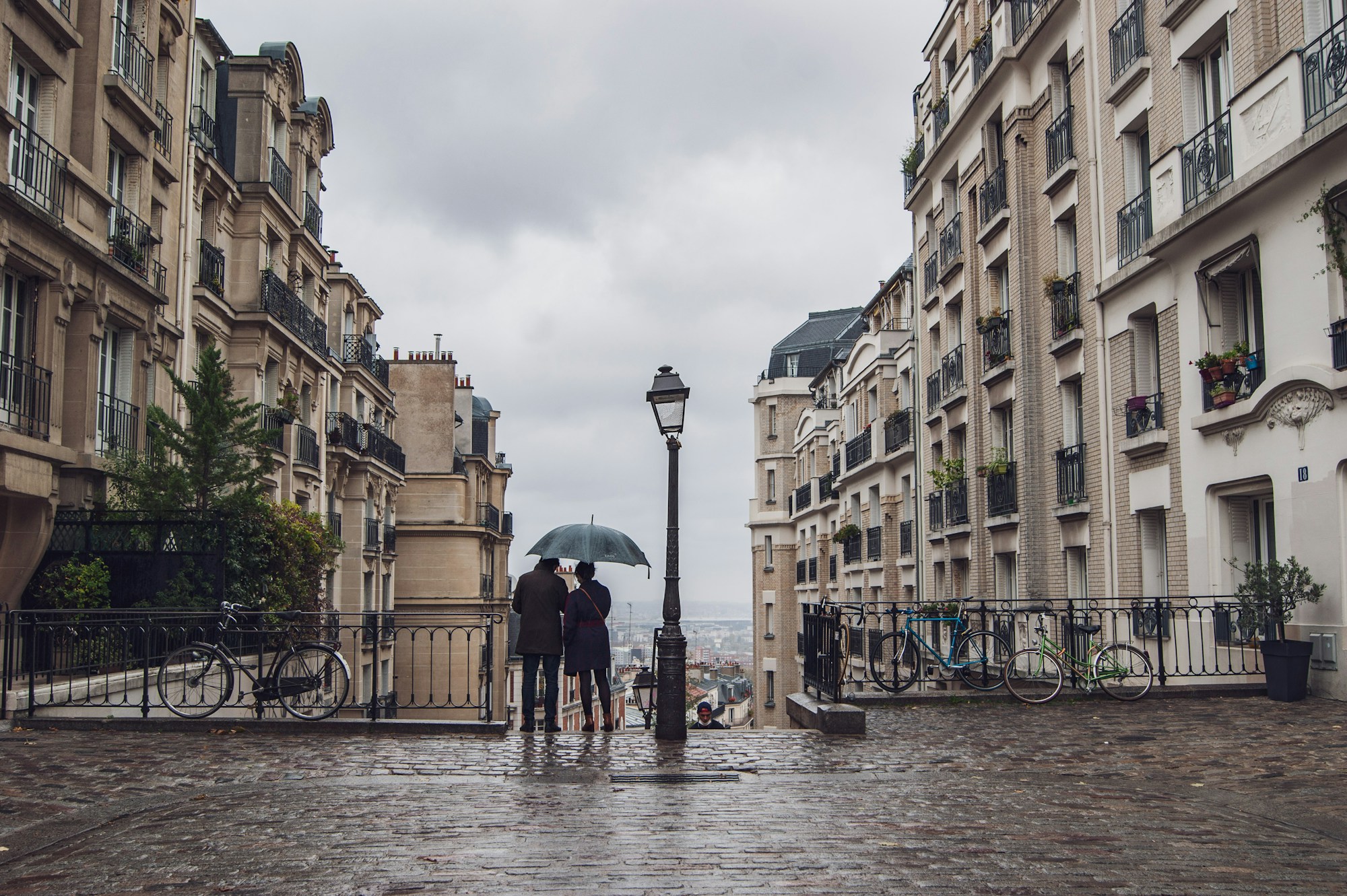 Rue parisienne pavée du 11ᵉ arrondissement, passants en journée