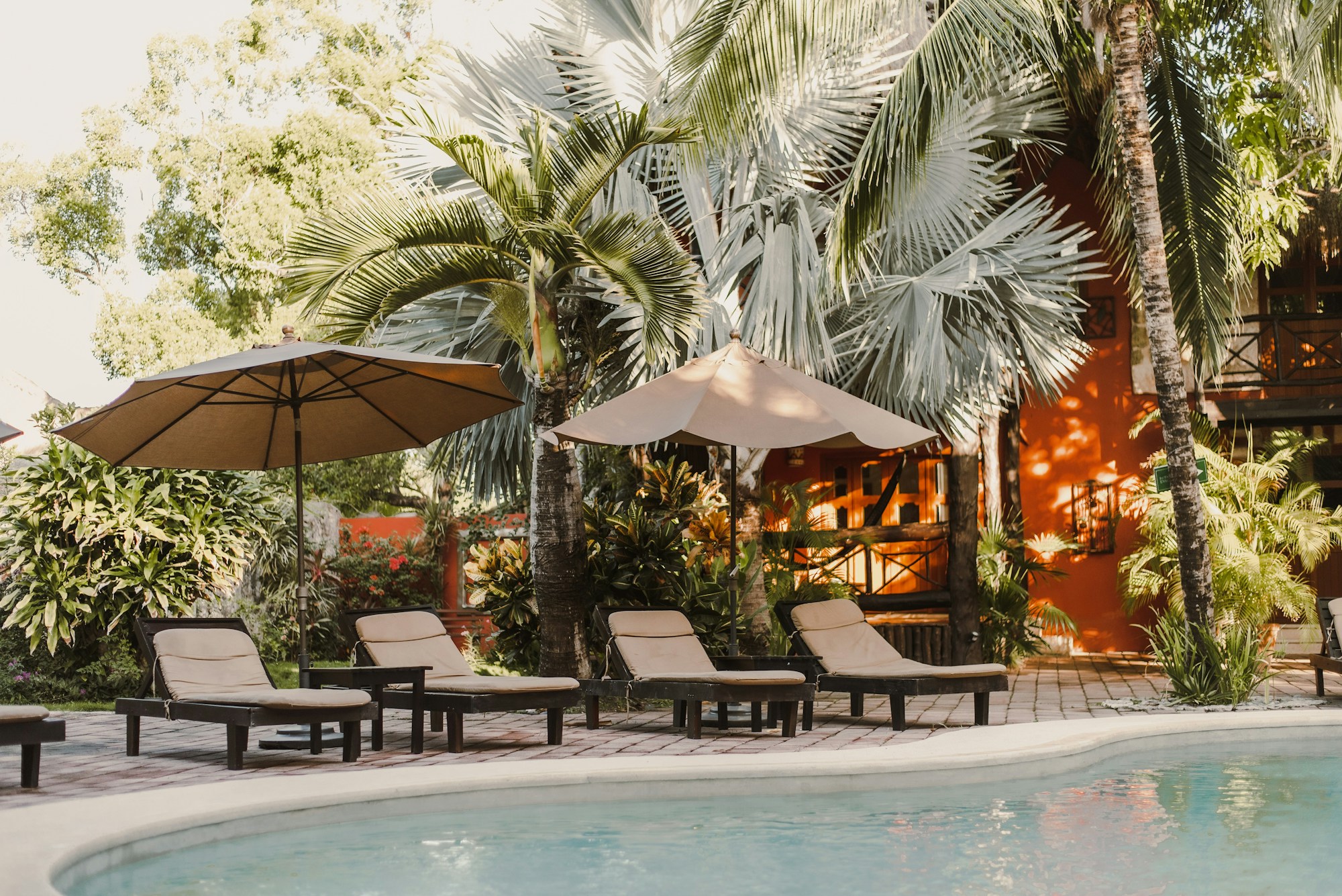 Patio extérieur d'hôtel boutique avec transats et piscine