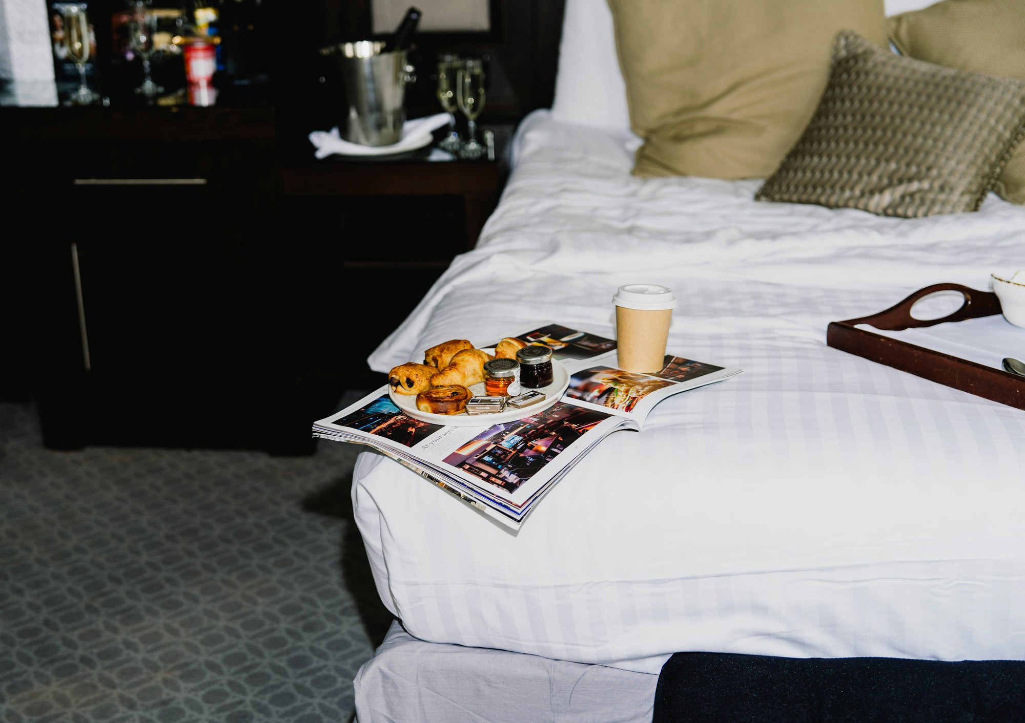 Plateau petit-déjeuner avec croissants et café sur lit d'hôtel